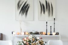 25 a stylish modern Thanksgiving tablescape with black and orange glasses, black chargers and white plates and neutral and pastel blooms is pure chic