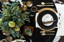 26 a stylish modern Thanksgiving tablescape in black, with a lush greenery, pears and artichoke centerpiece, black chargers and gold cutlery