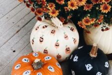 26 a white, orange and black pumpkin decorated with sharpie ghosts and jack-o-lanterns look very nice