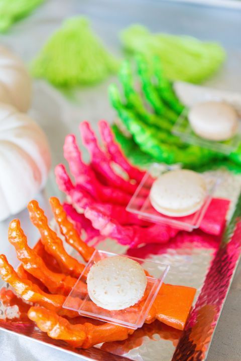 bold neon skeleton hands holding desserts are a cool and bold idea for a Halloween neon party