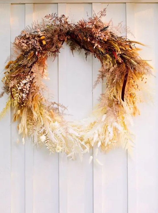 a fantastic ombre Thanksgiving wreath of dried leaves, herbs, greenery and some berries looks jaw dropping and strikes with color