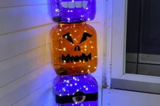 33 oversized purple and orange glass jars turned into jack-o-lanterns with LED lights are amazing for Halloween
