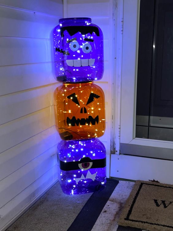 oversized purple and orange glass jars turned into jack-o-lanterns with LED lights are amazing for Halloween