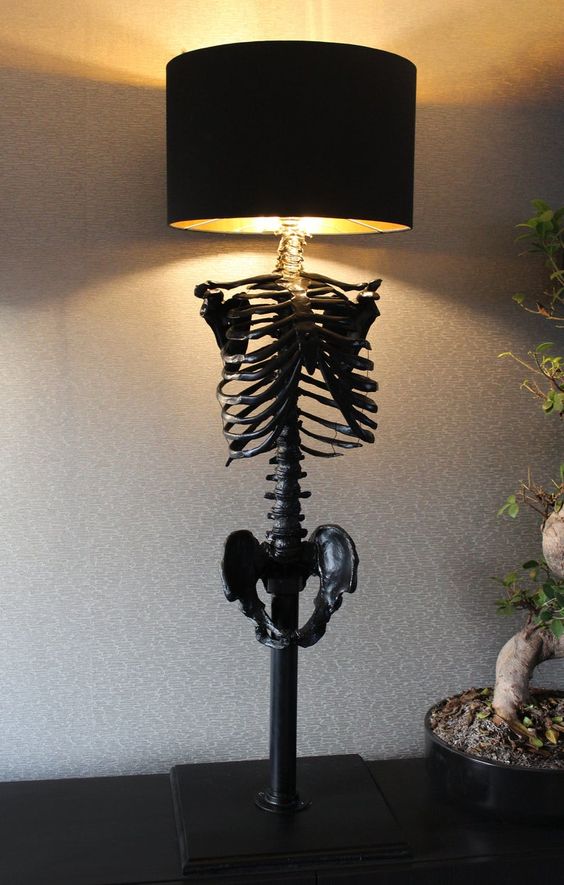 a black skeleton table lamp with a round lampshade is a stylish idea for Halloween decor and it looks scary