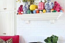 a bold and bright fall mantel with colorful pumpkins, plaid and color block ones plus yellow blooms in vases is amazing