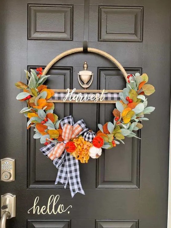 a bright Thanksgiving wreath of a hoop with faux leaves, berries, plaid ribbon and some mini colorful gourds is amazing