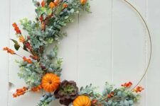 a bright fall or Thanksgiving wreath partly decorated with faux greenery, bold orange blooms, mini gourds and a succulent is chic