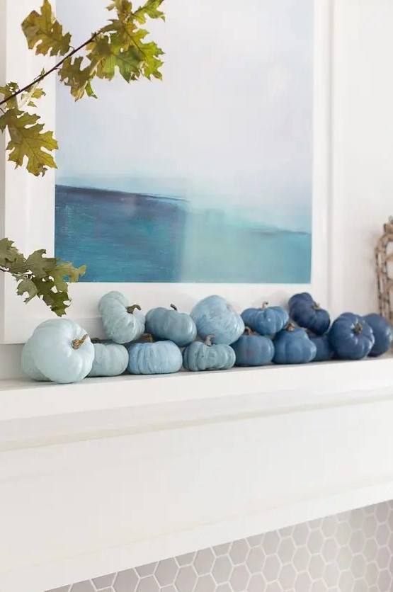 a coastal fall mantel decorated with faux veggies in various shades of blue to create an ombre effect