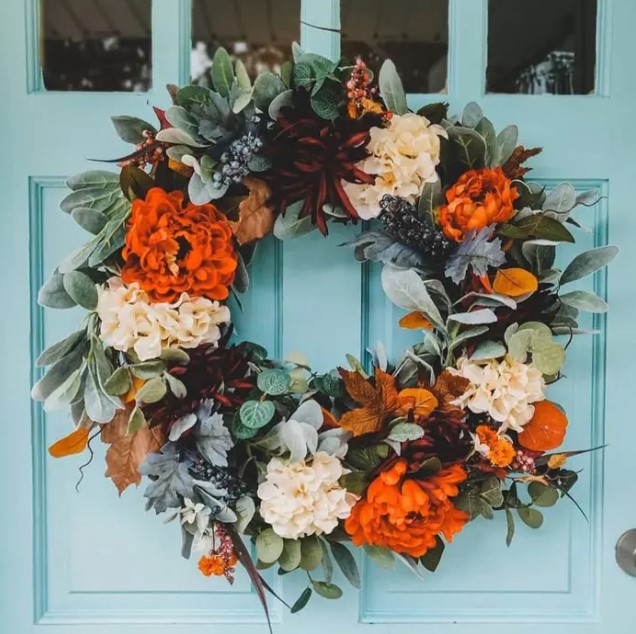 a colorful fall or Thanksgiving wreath with orange, burgundy and white blooms, greenery and foliage is amazing