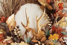 a fab Thanksgiving wreath of vine, twigs, faux bright foliage, antlers, pinecones and gilded berries is amazing
