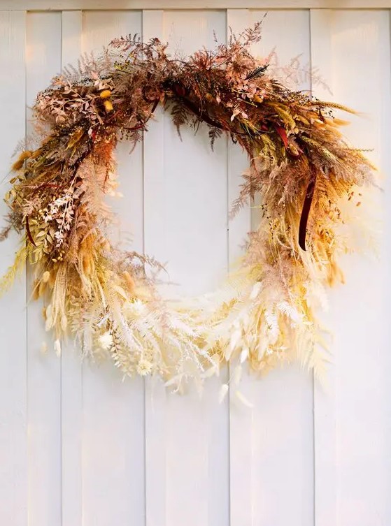 a fantastic ombre Thanksgiving wreath of dried leaves, herbs, greenery and some berries looks jaw-dropping and strikes with color