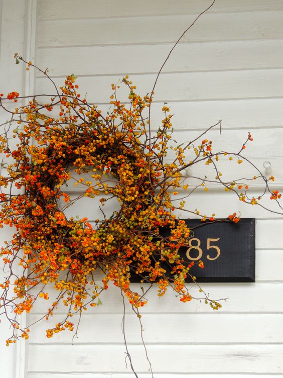a gorgeous Thanksgiving wreath of vine covered with berry and bloomign branches is a fantastic idea for the fall, too