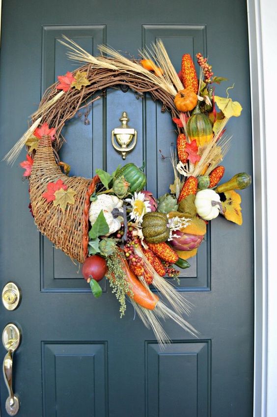 a gorgeous harvest-inspired wreath with faux veggies and fruits, a large cornucopia, grasses and foliage