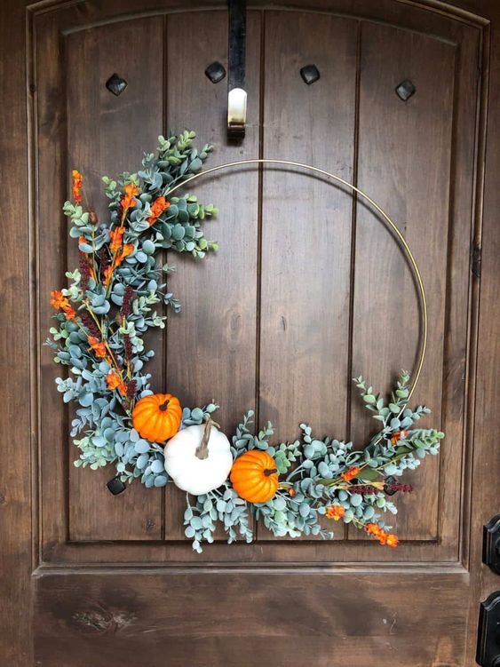 a modern embroidery hoop Thanksgiving wreath with faux greenery, blooms and mini pumpkins is a cool modern solution