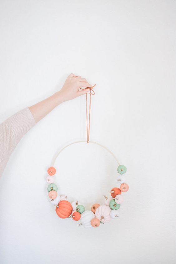 an easy modern fall or Thanksgiving wreath with white, blush, light green and coral faux pumpkins is a pretty idea