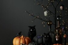 beautiful Halloween decor with a black LED tree, black ornaments, matte black and orange pumpkins and black owls