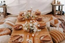 04 a boho thanksgiving feast space with terracotta linens, white blooms and rust candles plus lots of pillows