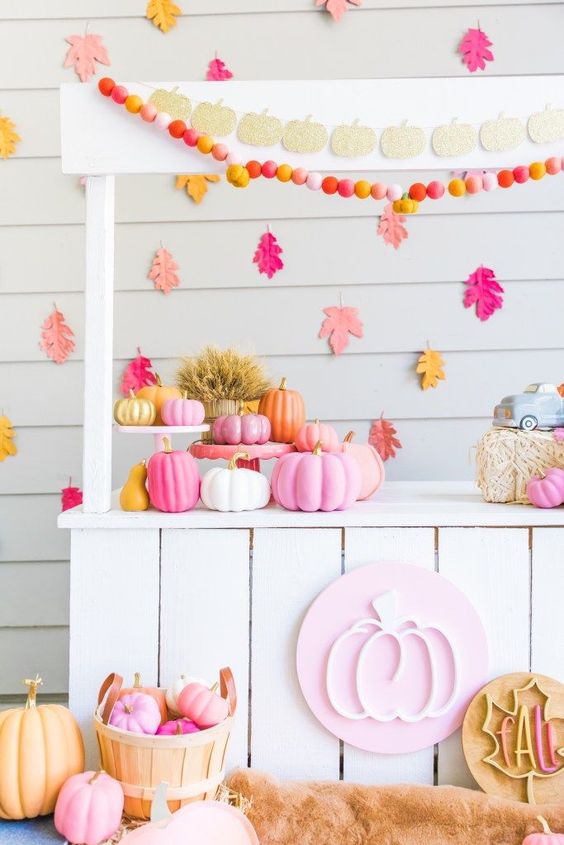a bright Thanksgiving pumpkin stand with colorful garlands and banners, bright pumpkins in baskets and bright leaves