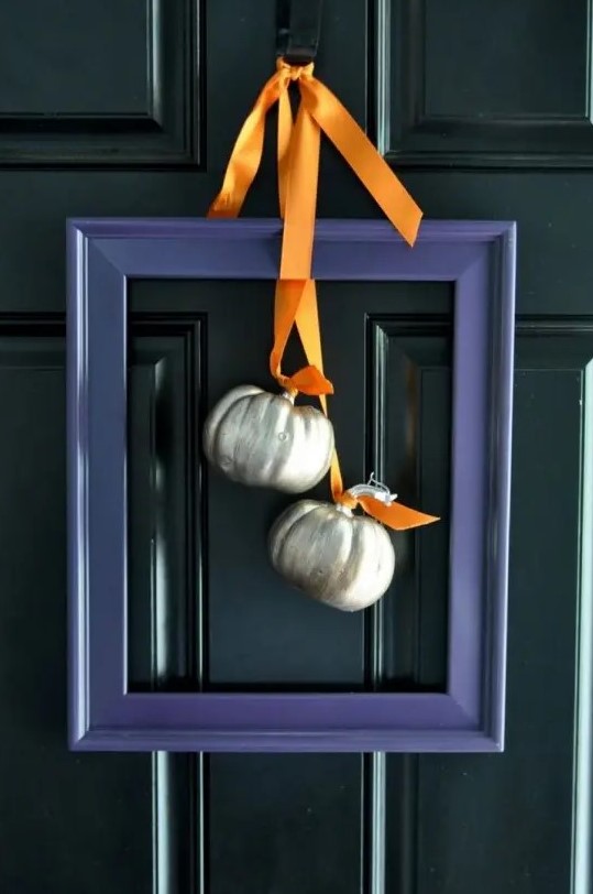 a modern alternative to a fall wreath - a purple frame with metallic pumpkins and orange ribbons is very stylish and bold