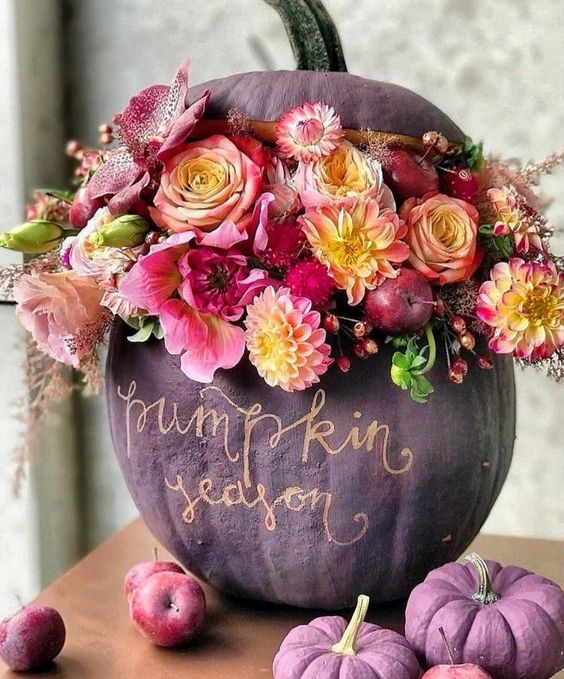 a sophisticated purple pumpkin with gold calligraphy, bold pink and yellow blooms, foliage and berries is amazing for Thanksgiving decor