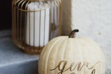 06 a pillar candle in a candle holder and a neutral pumpkin with letters compsoe a cool decoration for outdoors