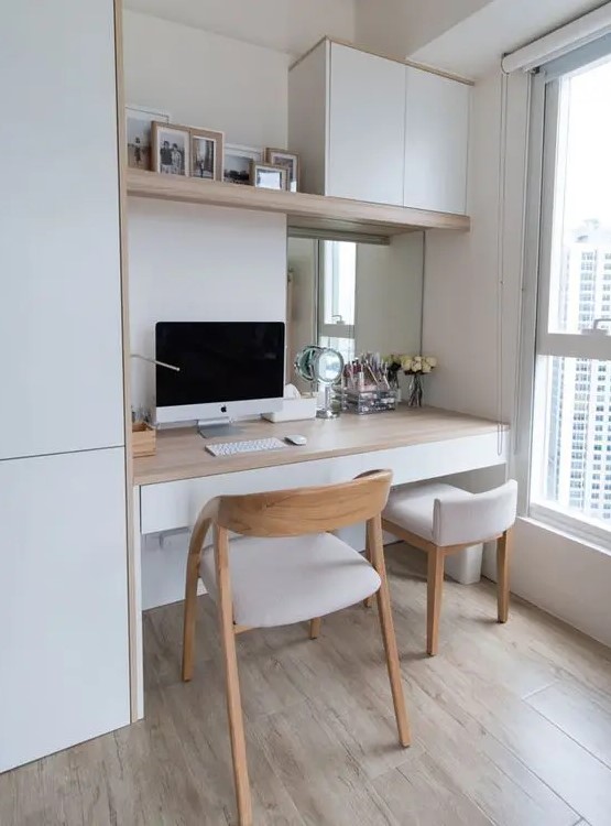 a Scandinavian home office nook by the window, with a built in desk, sleek storage unit, white chairs and some artworks