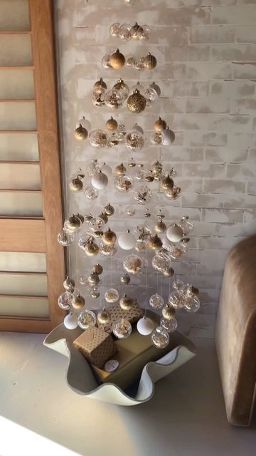 a floating Christmas tree of white, clear, gold ornaments is a beautiful solution for a modern space