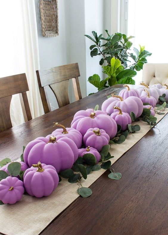 a pretty and cool Thanksgiving table runner of burlap, lilac and purple pumpkins with an ombre effect and greenery