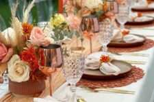 08 a colorful boho Thanksgiving tablescape with a yellow runner, bright blooms and grasses, orange woven placemats and copper glasses