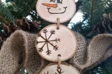 08 a wood slice snowman with wood burnt snowflakes and a face is a cool rustic Christmas ornament to rock