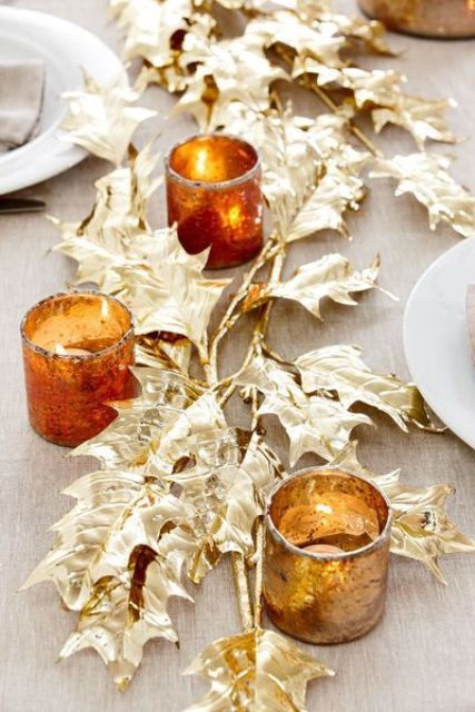 gold faux leaves and amber glass candleholders are great for styling a table for Thanksgiving