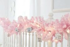 09 a pastel pink evergreen garland on the railing, mini houses and lights is gorgeous Christmas decor you can easily make