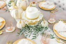 10 a beautiful glam Thanksgiving table setting with a striped runner and speckled plates, gold cutlery and glam embellished pumpkins plus greenery
