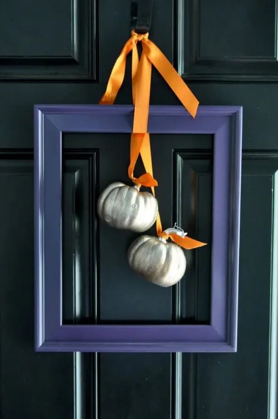 a modern alternative to a fall wreath - a purple frame with metallic pumpkins and orange ribbons is very stylish and bold