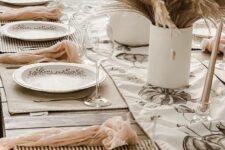 12 a neutral boho Thanksgiving tablescape with wheat and grass centerpieces, striped placemats, blush napkins and printed plates