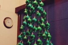 12 a small suspended Christmas tree of shiny, matte and glitter emerald ornaments hanging on different heights