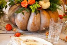 12 an oversized heirloom pumpkin with greenery, bright blooms and mini white pumpkins as a bold Thanksgiving centerpiece