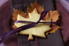 13 a bold purple place setting with bright purple fabric, purple layered plates, a brown napkin and a leaf cookie is amazing