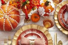 13 a bright and whissy Thanksgiving tablescape with gold chargers, cutlery, colorful pumpkins and floral arrangements, bold candles