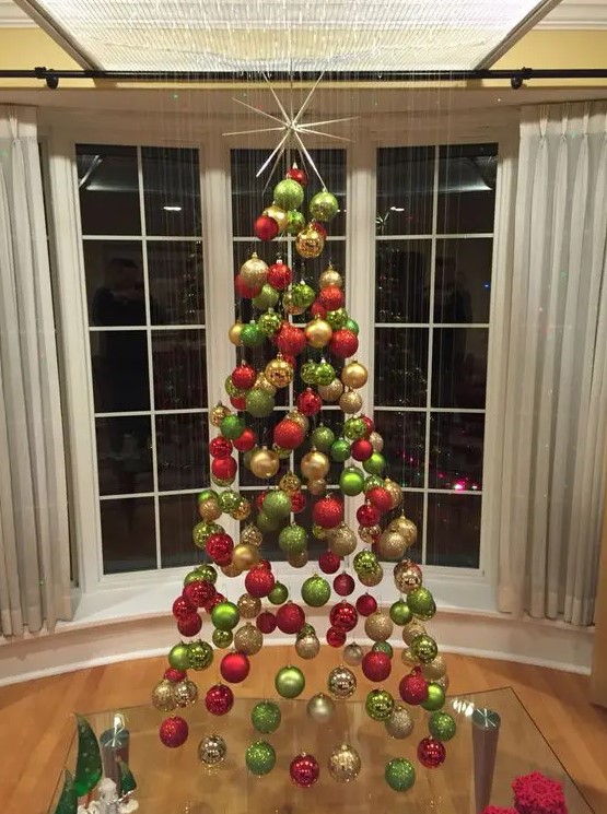 a suspended Christmas tree of ornaments in traditional Christmas colors, green, red and gold is a fun idea