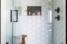14 a chic shower space with black penny and white hex tiles, seamless glass doors with a black handle and black fixtures