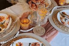 14 a pretty boho Thanksgiving table setting with a rust runner, a large rust rose and dried frond centerpiece, wooden beads, woven placemats