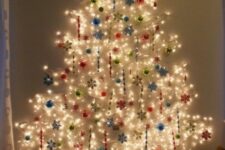 15 a Christmas tree of lights on the wall with various ornaments – balls and snowflakes in various colors
