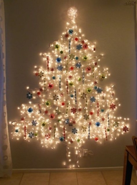 a Christmas tree of lights on the wall with various ornaments   balls and snowflakes in various colors