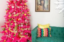 15 a hot pink Christmas tree with green and gold ornaments, pompom garlands and a quirky topper