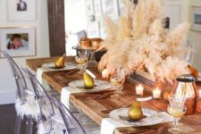 15 a relaxed boho Thanksgiving tablescape with printed plates, white napkins, candles, a pampas grass centerpiece and copper jugs