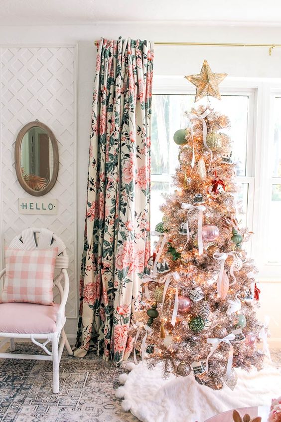 a chic Christmas tree styled with pastel green and pink ornaments, with ribbon bows and a gold star topper