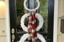 16 a white snowman made of white wreaths, a plaid scarf and a black top hat is a cool alternative to a usual Christmas wreath on your door