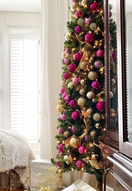 a refined Christmas tree with lights, gold and hot pink and fuchsia ornaments and ribbons is a gorgeous idea for a chic holiday space