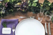 20 a chic Thanksgiving tablescape with a greenery runner, purple napkins and berries, white porcelain and chic cutlery is amazing